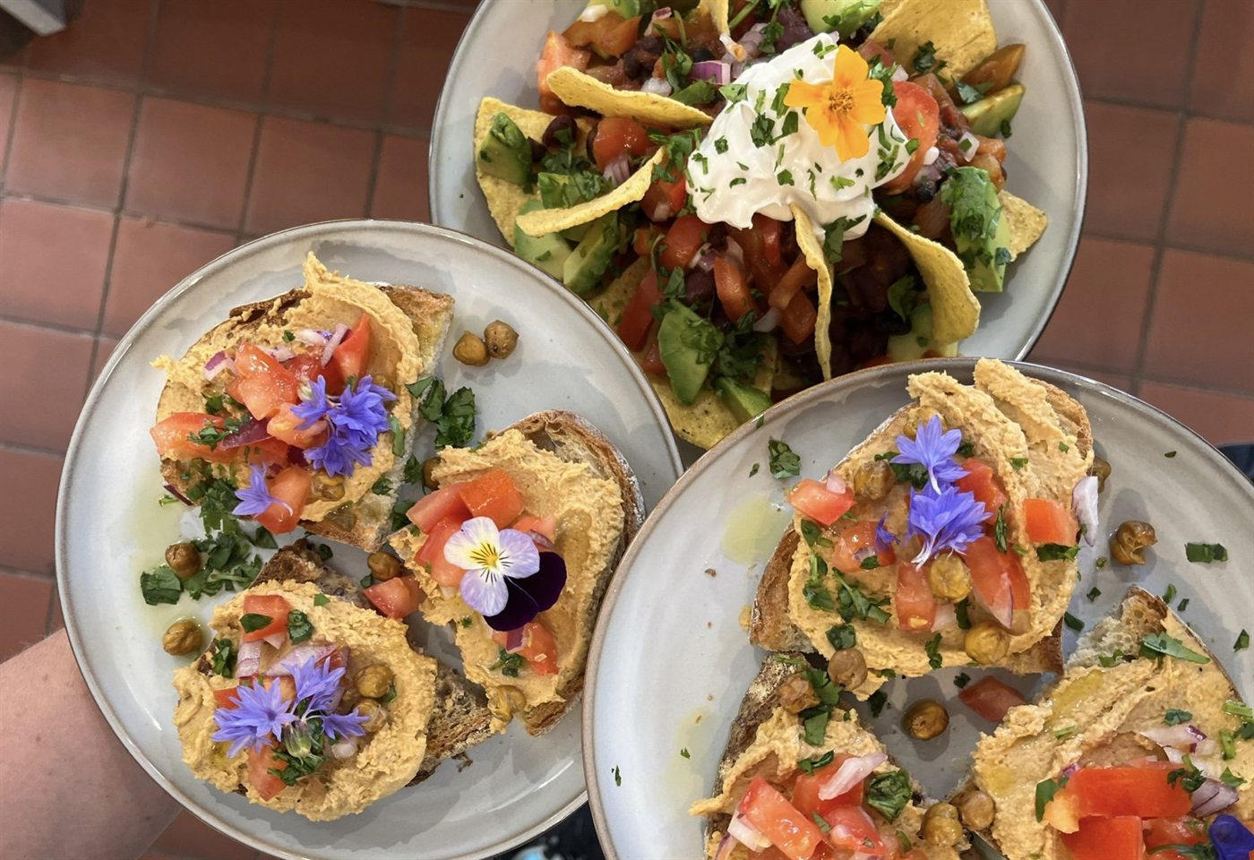 Two colourful brunch plates finished with edible flowers