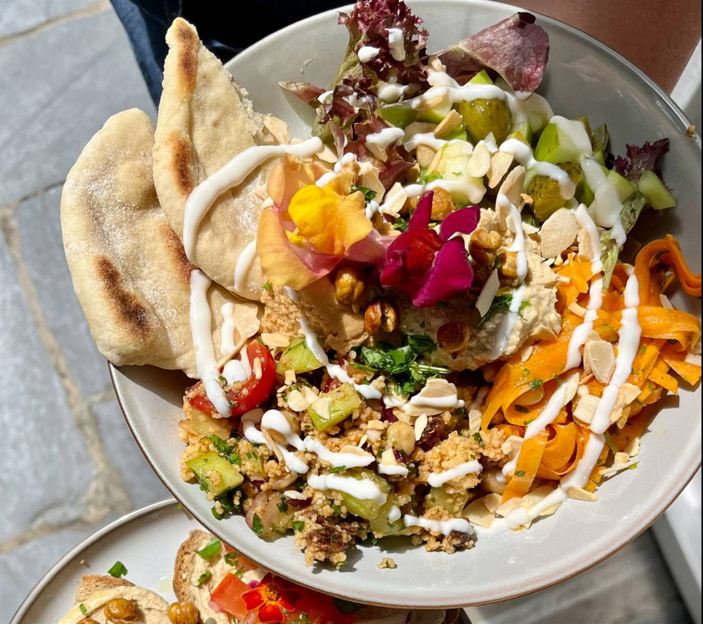 A colourful plant-based plate with salad and flatbread