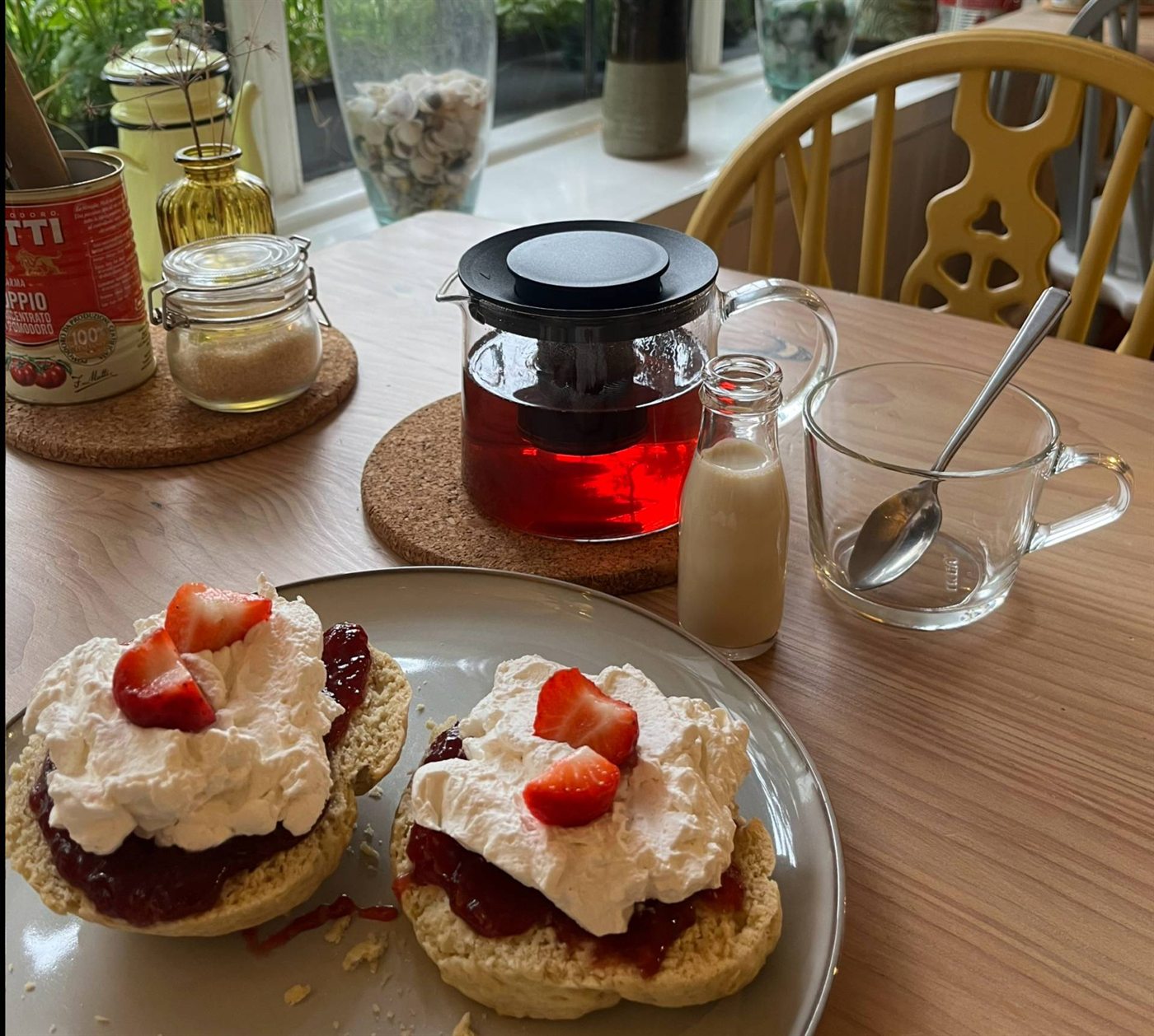 Tea and scones served at a light wooden cafe table